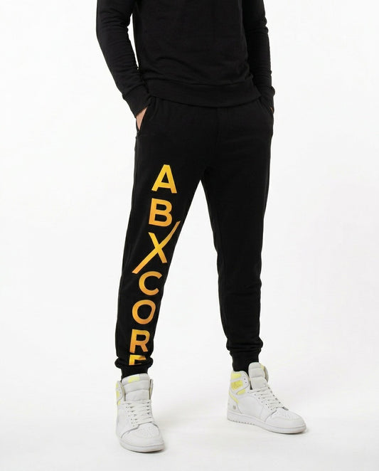 Front view of man wearing black AbXcore joggers with plain black back, on a white background