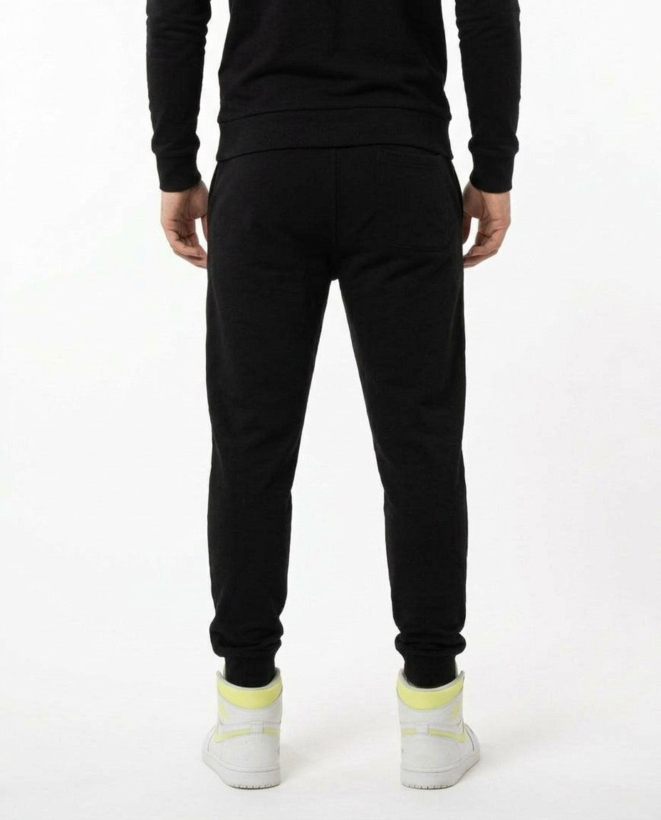 Back view of man wearing black AbXcore joggers with plain black back, on a white background