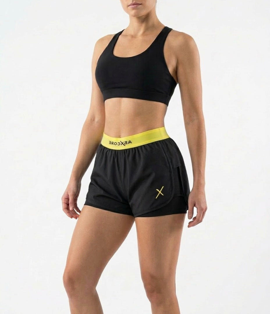 woman wearing black ABXCORE women’s training short with yellow waistband front view