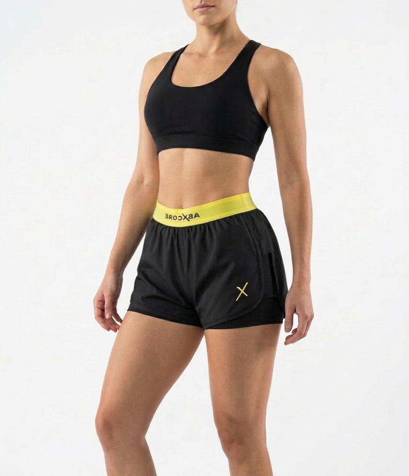 woman wearing black ABXCORE women’s training short with yellow waistband front view